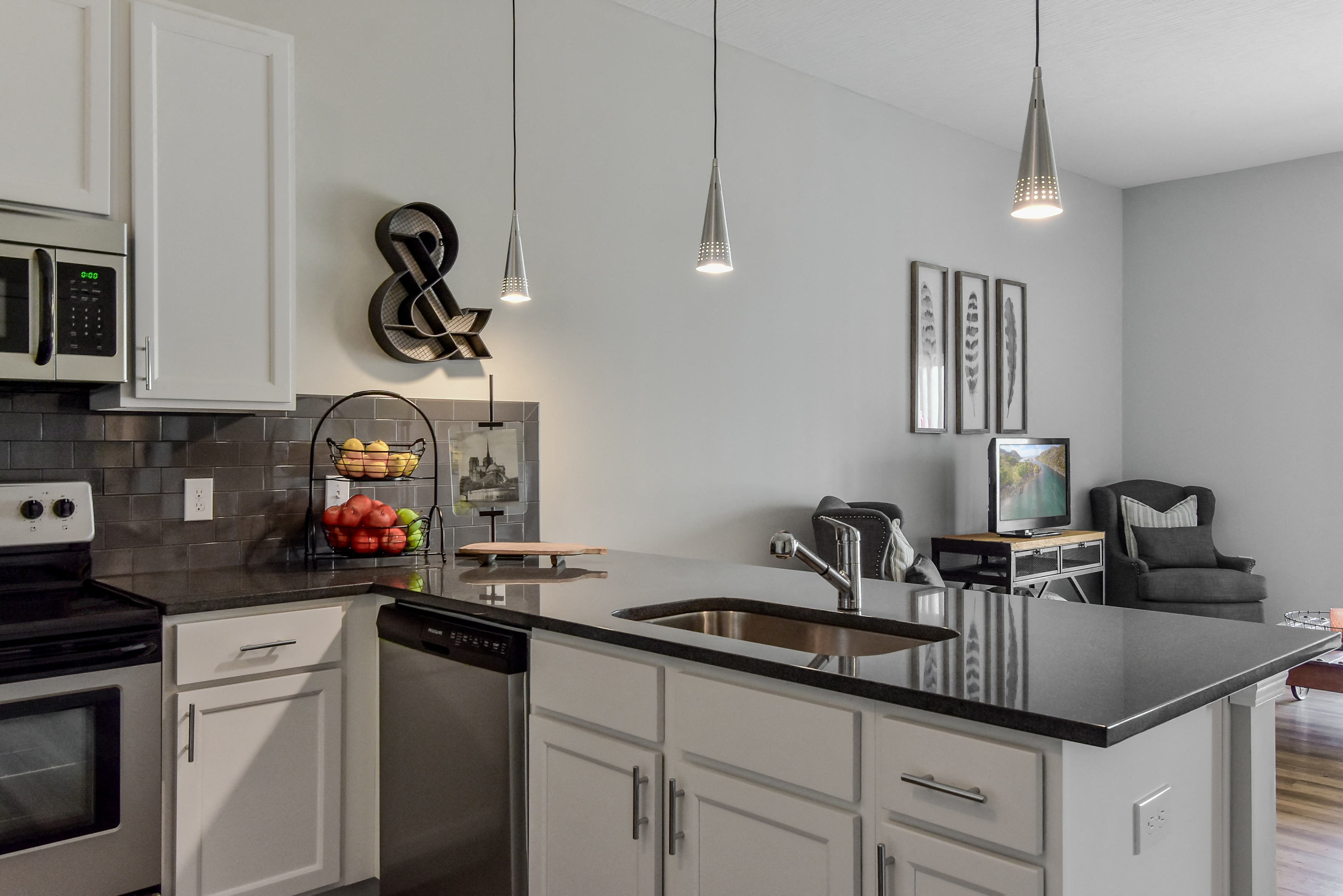an open kitchen and living room with a large counter top